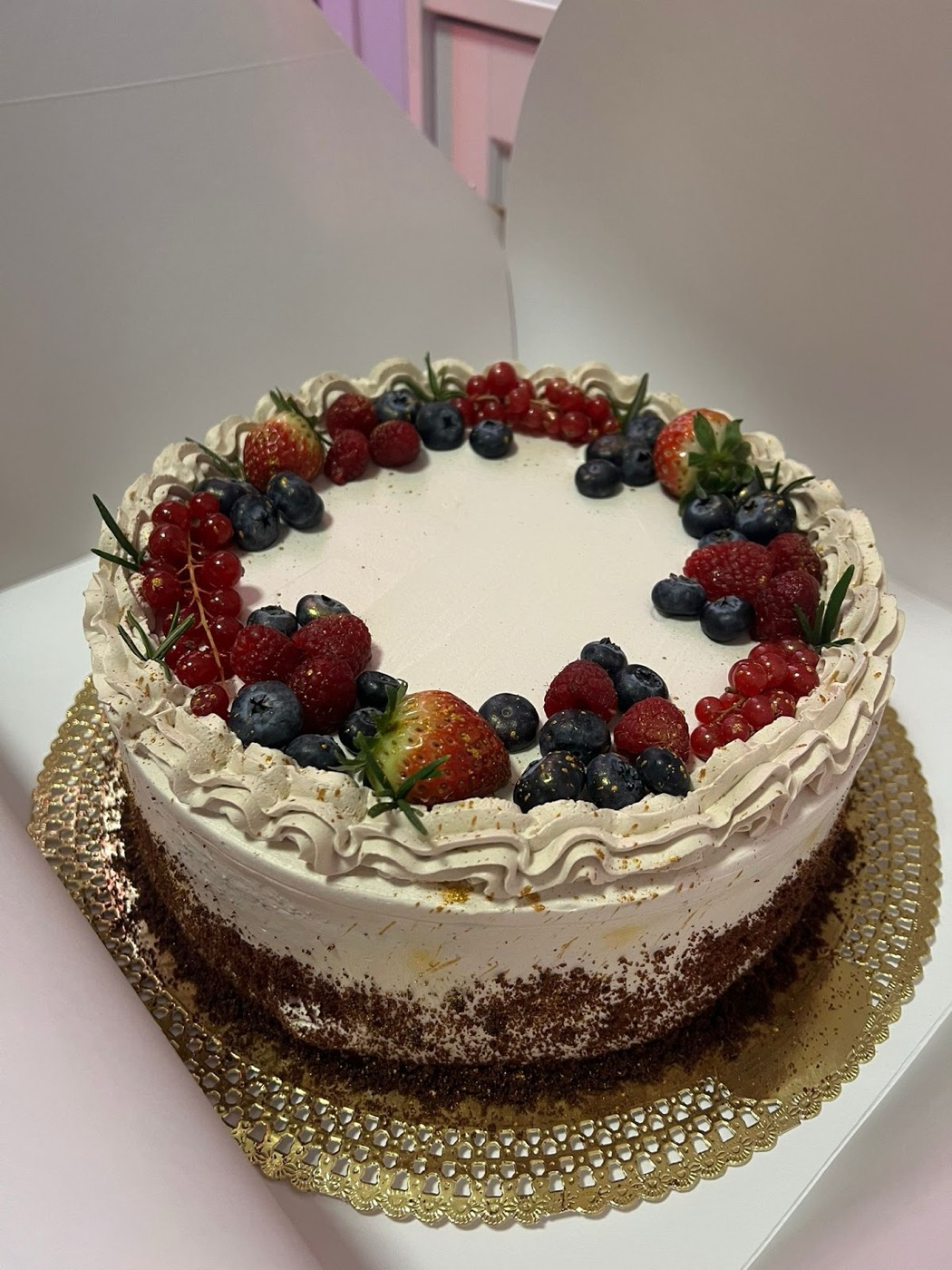 Torta decorata con frutti di bosco freschi su vassoio dorato